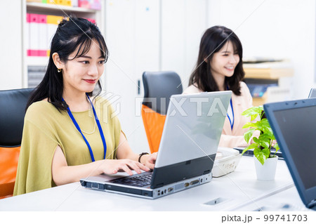 オフィスでデスクワークをする女性スタッフ オフィスでデスクワークをする女性スタッフ 99741703