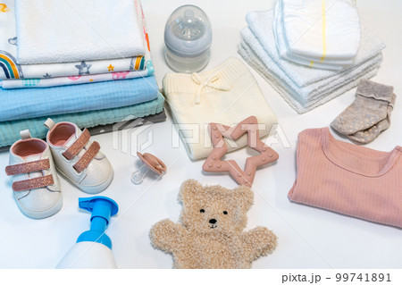 Concept of giving birth. Set of clothes and accessories for newborn on white background 99741891