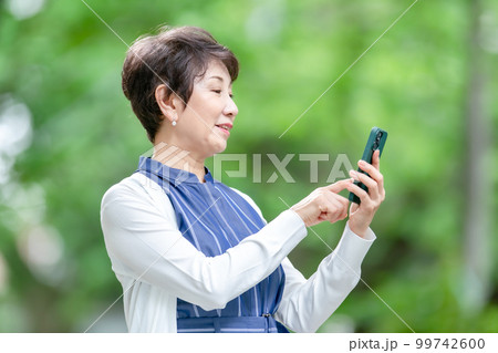 新緑 シニア女性 スマホ 新緑 シニア女性 スマホ 99742600