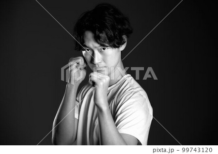 ファイティングポーズをとる若い男性　モノクロイメージ 99743120