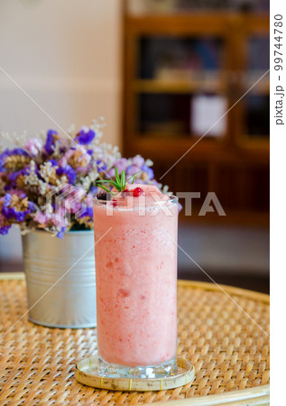 stawberrt smoothie yogurt in high glass on wooden table 99744780