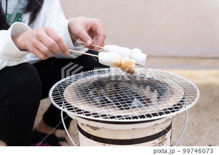 七輪で焼きマシュマロをする子供 99746073