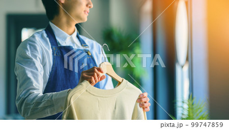 衣料品を持った男性店員 衣料品を持った男性店員 99747859
