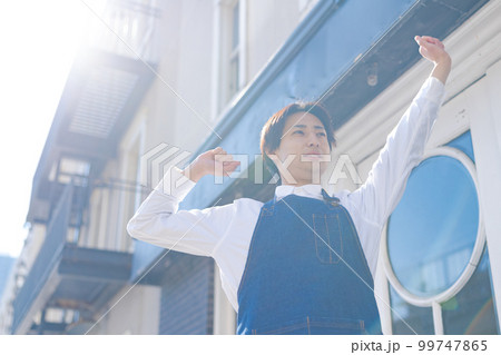 伸びをする男性お店のスタッフ 伸びをする男性お店のスタッフ 99747865