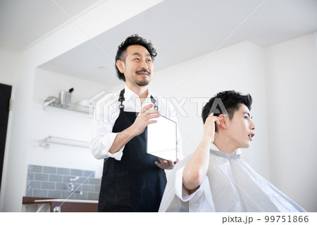 髪の毛の確認をする美容師とお客様 髪の毛の確認をする美容師とお客様 99751866