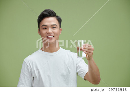 young man holds a glass of pure water young man holds a glass of pure water 99751918