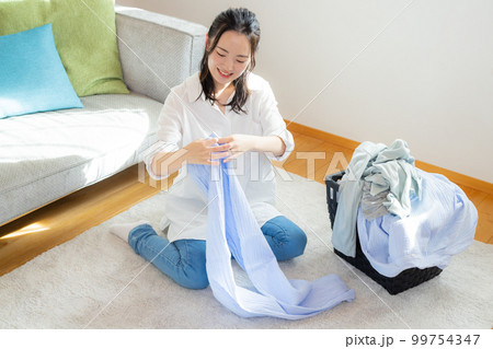 洗濯物を畳む女性 洗濯物を畳む女性 99754347
