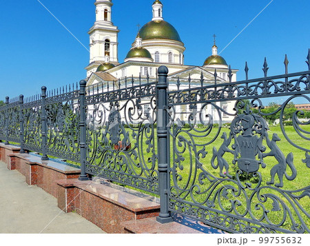 Forged fence around the Nevyansk leaning tower. On the fence is the coat of arms of the Demidov family. In the background is the Transfiguration Cathedral. Nevyansk, Russia Forged fence around the Nevyansk leaning tower. On the fence is the coat of arms of the Demidov family. In the background is the Transfiguration Cathedral. Nevyansk, Russia 99755632
