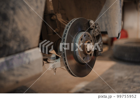 Car brake part in the garage, car brake disc without wheels. Car suspension. Current car repair Car brake part in the garage, car brake disc without wheels. Car suspension. Current car repair 99755952