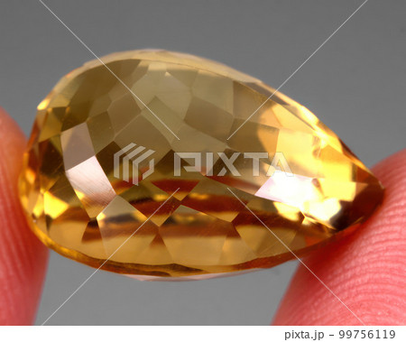 Natural gemstone yellow citrine on gray background 99756119