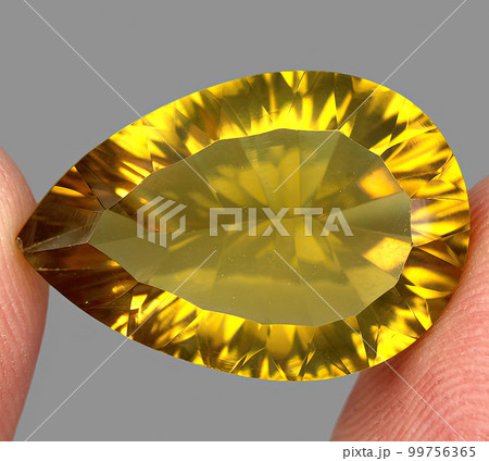 Natural gemstone yellow citrine on gray background 99756365