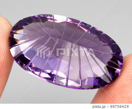 Natural gemstone purple amethyst on gray background Natural gemstone purple amethyst on gray background 99756429