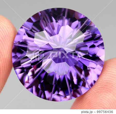 Natural gemstone purple amethyst on gray background 99756436