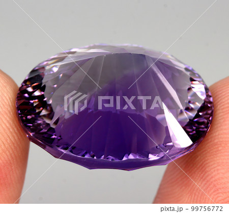 Natural gemstone purple amethyst on gray background Natural gemstone purple amethyst on gray background 99756772