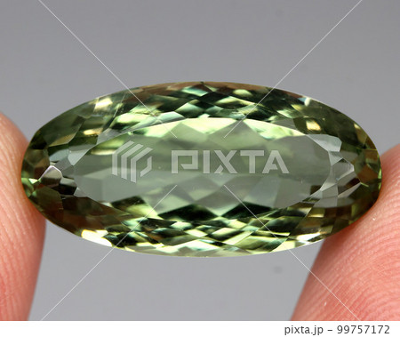 Natural stone green amethyst on a gray background Natural stone green amethyst on a gray background 99757172