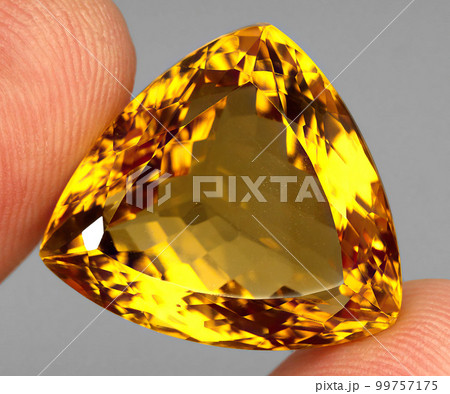 Beautiful natural citrine gemstone on a gray background Beautiful natural citrine gemstone on a gray background 99757175
