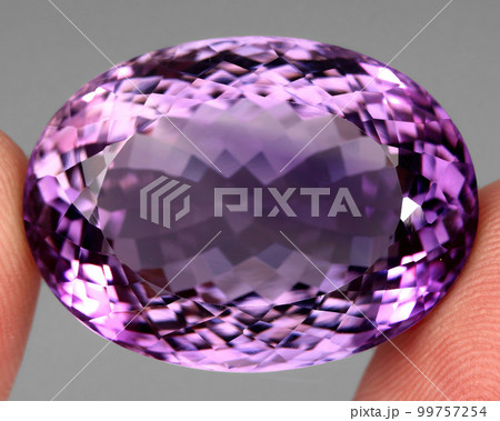 Natural gemstone purple amethyst on gray background Natural gemstone purple amethyst on gray background 99757254