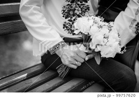 A bouquet of flowers in the hands of the bride. A bouquet of white flowers in the hands of a woman. Wedding A bouquet of flowers in the hands of the bride. A bouquet of white flowers in the hands of a woman. Wedding 99757620