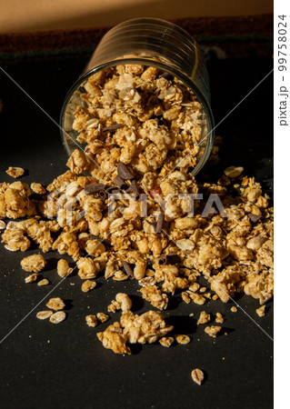 Homemade granola with nuts and seeds in eco tableware jar. Healthy snack on breakfast. Muesli from oatmeal, raisins, honey, cranberry, flax, almond, cashew, freshly baked  99758024