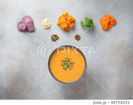 dark bowl with pumpkin soup with seeds, spices and food ingredients. 99758053