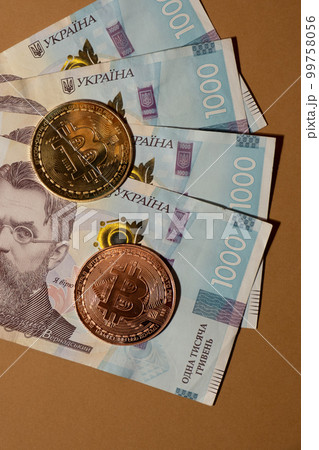 Bitcoin gold coin on bills of 1000 Ukrainian hryvnia currency. Bitcoin mining trading concept. BTC golden money spinning around. Worldwide virtual internet Cryptocurrency or crypto digital payment Bitcoin gold coin on bills of 1000 Ukrainian hryvnia currency. Bitcoin mining trading concept. BTC golden money spinning around. Worldwide virtual internet Cryptocurrency or crypto digital payment 99758056