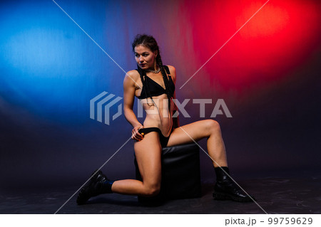 Beautiful female body on dark background in red blue neon light. Fit and sportive, sensual. 99759629
