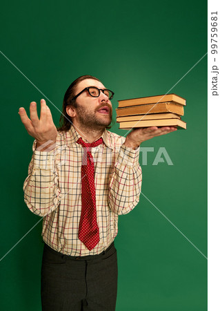 Portrait of retro mature man with moustache and beard in eyeglasses posing in vintage fashion clothes over dark green background. 99759681