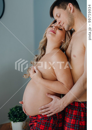 A Pregnant Woman Topless In Pajama Pants In Profile In A Home Interior.  Stock Photo, Picture and Royalty Free Image. Image 199459323.