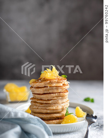 stack of whole grain flour pancakes, decorated with orange and mint. stack of whole grain flour pancakes, decorated with orange and mint. 99760242