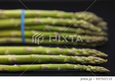 Green asparagus on black background 99760510