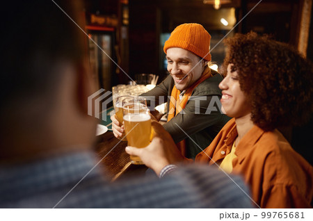 Friends watching football game online video on smartphone rest in sports bar Friends watching football game online video on smartphone rest in sports bar 99765681