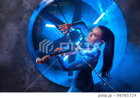 Artistic woman performer playing violin in atmospheric studio 99765724