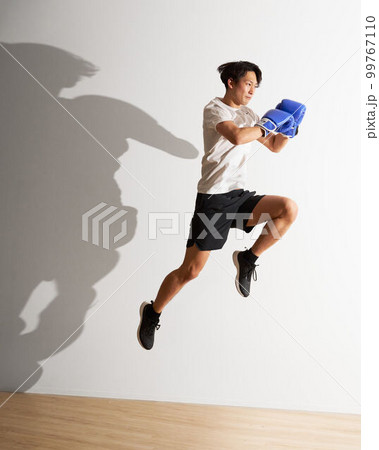 ジャンピングニーキックをする若い男性　トレーニング　キックボクササイズ　イメージ 99767110