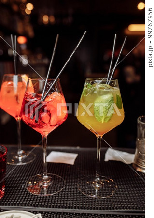 Refreshing grapefruit cocktail with ice and rosemary on a grey background. Refreshing grapefruit cocktail with ice and rosemary on a grey background. 99767956