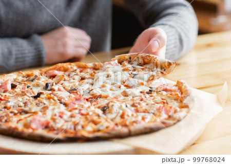 one people taking slices of pizza out of the box. fast delivery of food. packaging for fast food. top view one people taking slices of pizza out of the box. fast delivery of food. packaging for fast food. top view 99768024