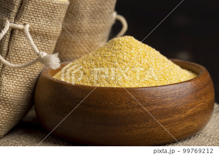 Round wooden bowl with dry corn flour Round wooden bowl with dry corn flour 99769212