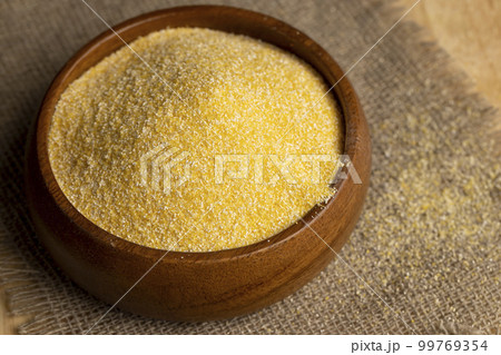 Round wooden bowl with dry corn flour Round wooden bowl with dry corn flour 99769354