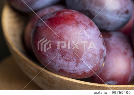 Ripe plums of dark color on the table Ripe plums of dark color on the table 99769400