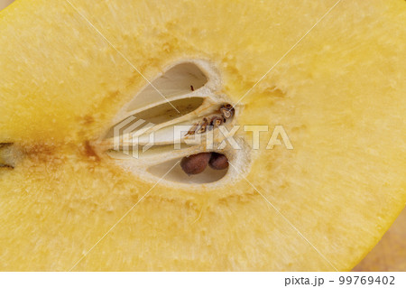 Sliced ripe yellow quince on a cutting board 99769402