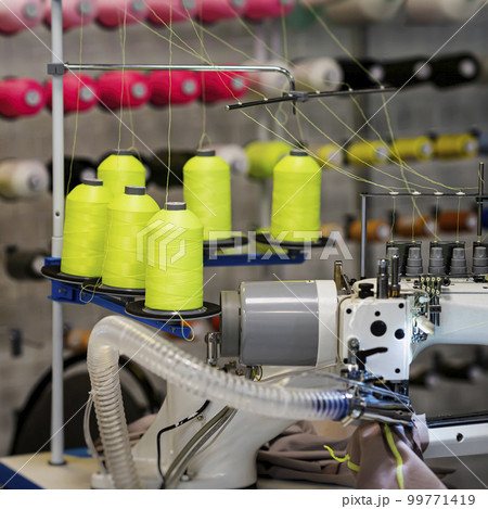 Several spools of colorful cotton thread on sewing machine, textile industry, industrial concept Several spools of colorful cotton thread on sewing machine, textile industry, industrial concept 99771419