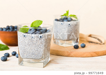 Healthy breakfast or morning with chia seeds vanilla pudding and blueberry berries on table background, vegetarian food, diet and health concept. Chia pudding with coconut milk and blueberry 99771649