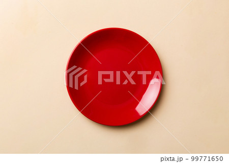 Top view of isolated of colored background empty round red plate for food. Empty dish with space for your design Top view of isolated of colored background empty round red plate for food. Empty dish with space for your design 99771650