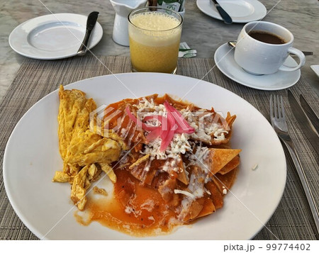 Chilaquiles with egg and juice at hotel restaurant Chilaquiles with egg and juice at hotel restaurant 99774402