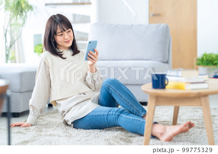 女性 リラックス ライフスタイル スマホ リビング 女性 リラックス ライフスタイル スマホ リビング 99775329