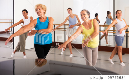Group of active women practicing energetic dance in a studio 99775684