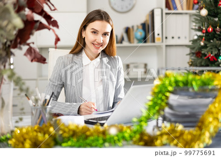 Successful business woman using laptop at workplace during christmas Successful business woman using laptop at workplace during christmas 99775691