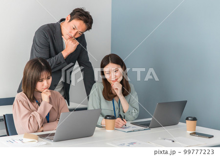 オフィスでノートパソコンを見ながら困るビジネスマンとビジネスウーマン 99777223