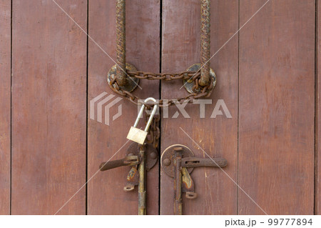 The Closed padlock hangs on the old doors. 99777894