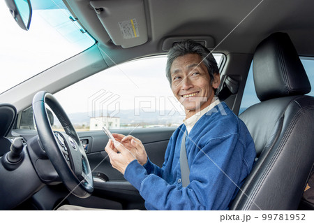 自動車を停めてスマートフォンを使うシニア男性 99781952