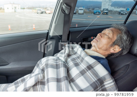 自動車の運転に疲れ仮眠をとるシニア男性 自動車の運転に疲れ仮眠をとるシニア男性 99781959